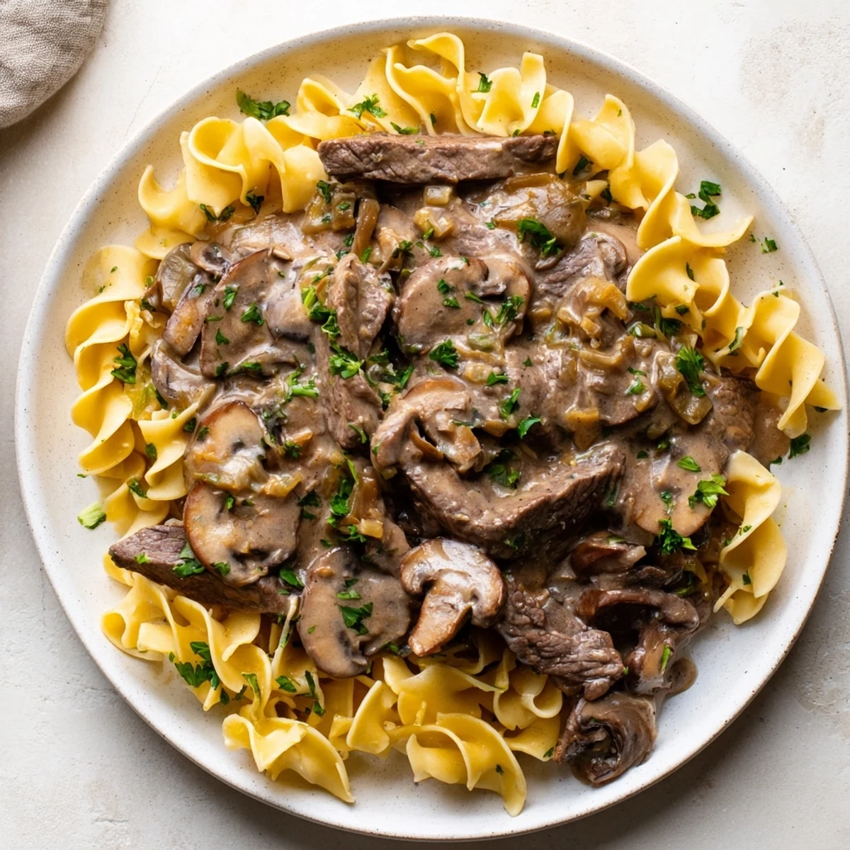 Tender beef stroganoff, a creamy classic served over golden egg noodles, ready to be enjoyed!