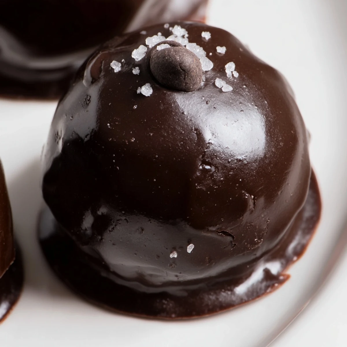 Chocolate Chip Cookie Dough Truffles displayed on a white platter, dusted with powdered sugar for a festive look.