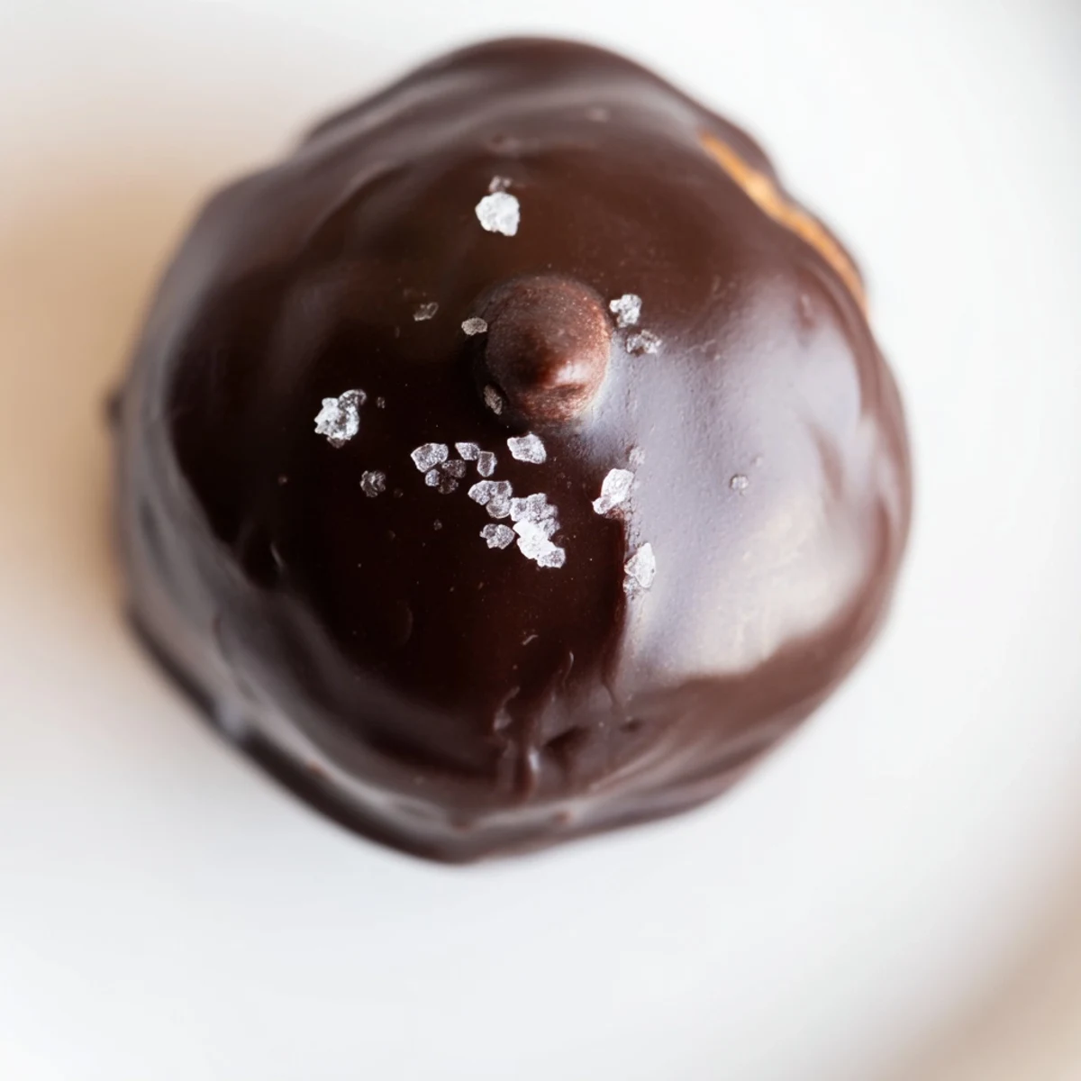Hand holding a Chocolate Chip Cookie Dough Truffle on parchment, perfect party-ready bite-sized dessert.