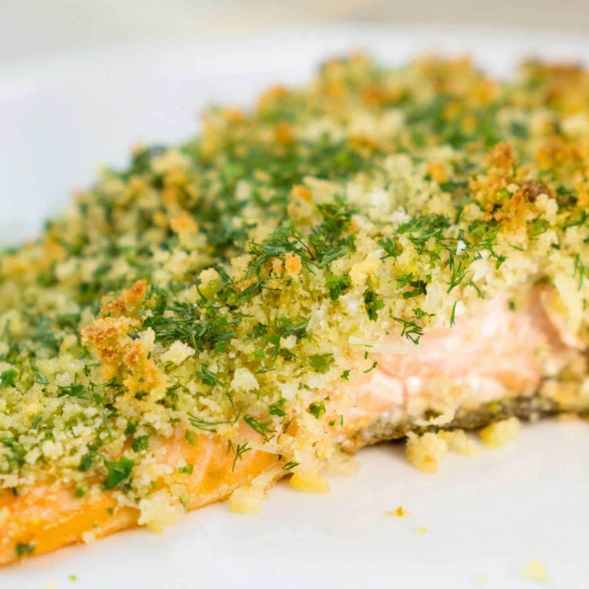 Golden-baked Herb Crusted Salmon with Dill fillets, topped with a crispy, aromatic herb crust, served simply on a white plate.