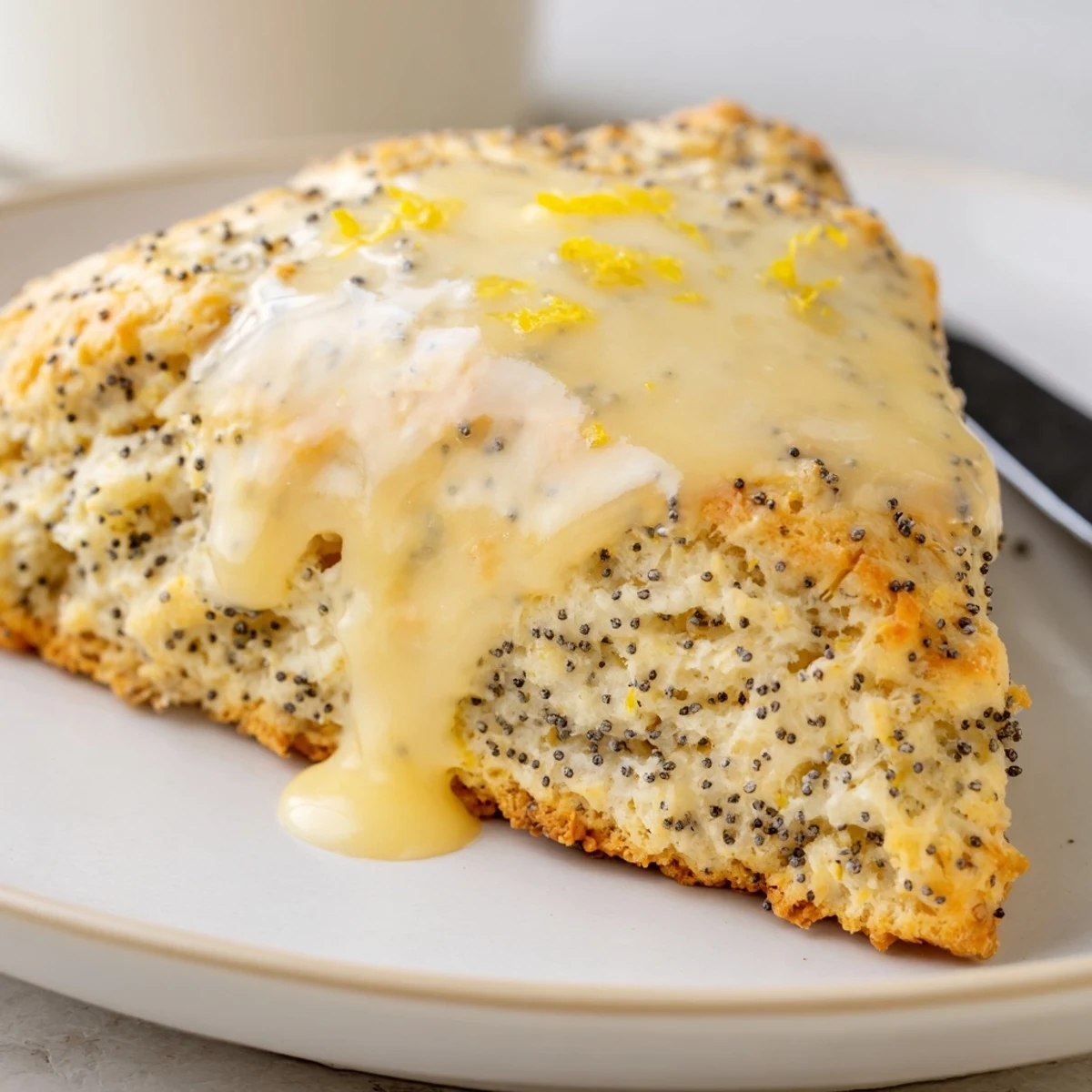 Warm Lemon Poppy Seed Scones on a wire rack, featuring crunchy poppy seeds and zesty lemon aroma.