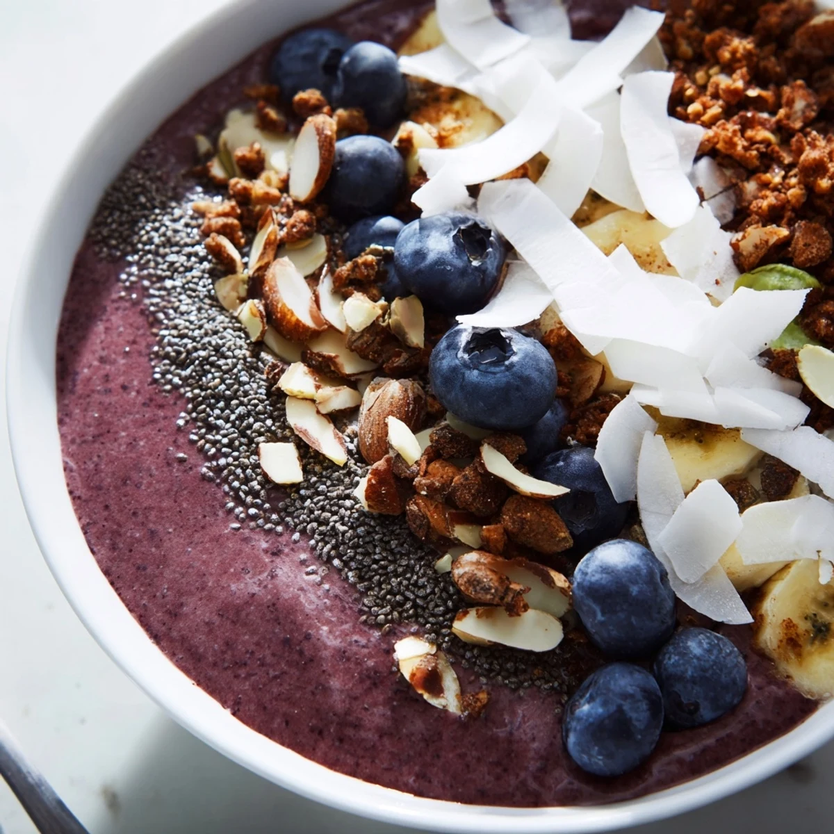 This Winter Berry Smoothie Bowl is topped with crunchy granola, sliced almonds, and cacao nibs for a satisfying texture. 