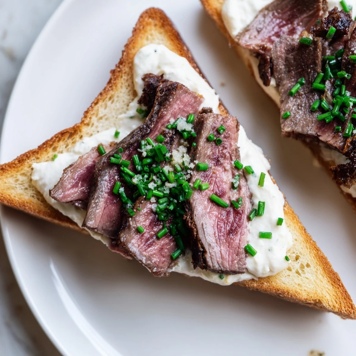 Crusty toast triangles spread with zesty horseradish cream and garnished with fresh chives, ready to serve.