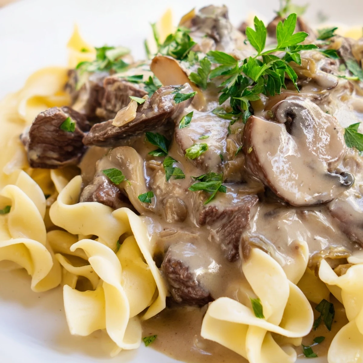 Golden egg noodles topped with creamy Beef Stroganoff featuring tender beef strips and sautéed mushrooms.