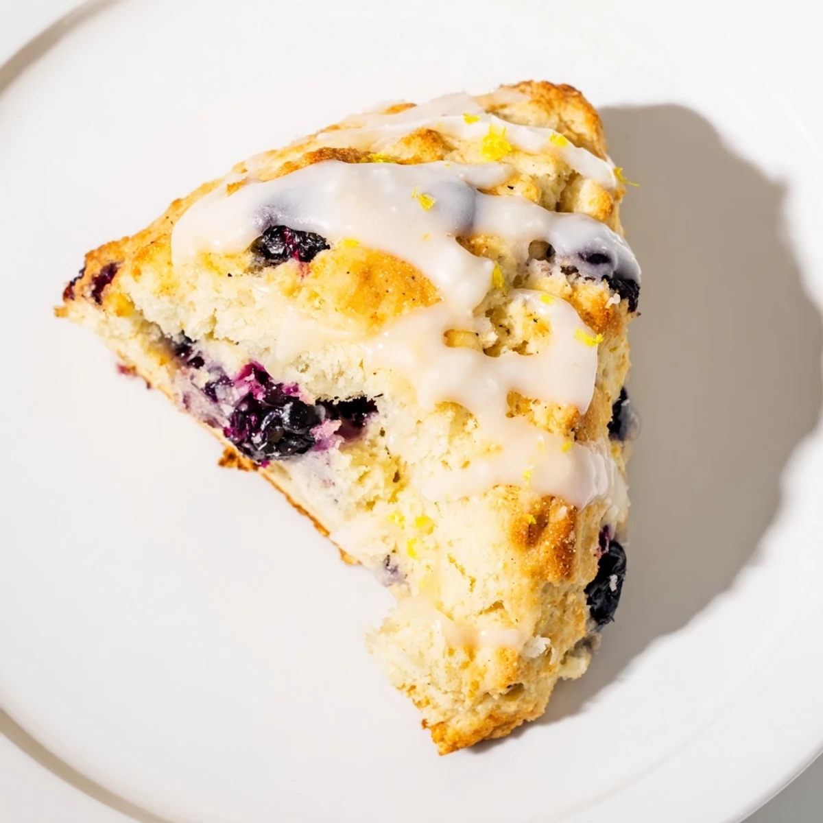 Freshly baked Lemon Blueberry Scones with Vanilla Glaze, showing golden edges and vibrant berries, ready for breakfast.