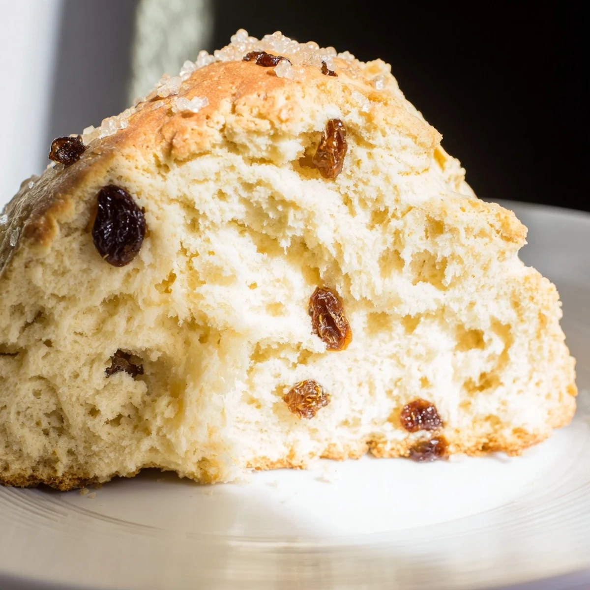 Freshly baked Irish Soda Bread Scones with Currants on a rustic wooden board, showing golden edges and plump dried fruit.