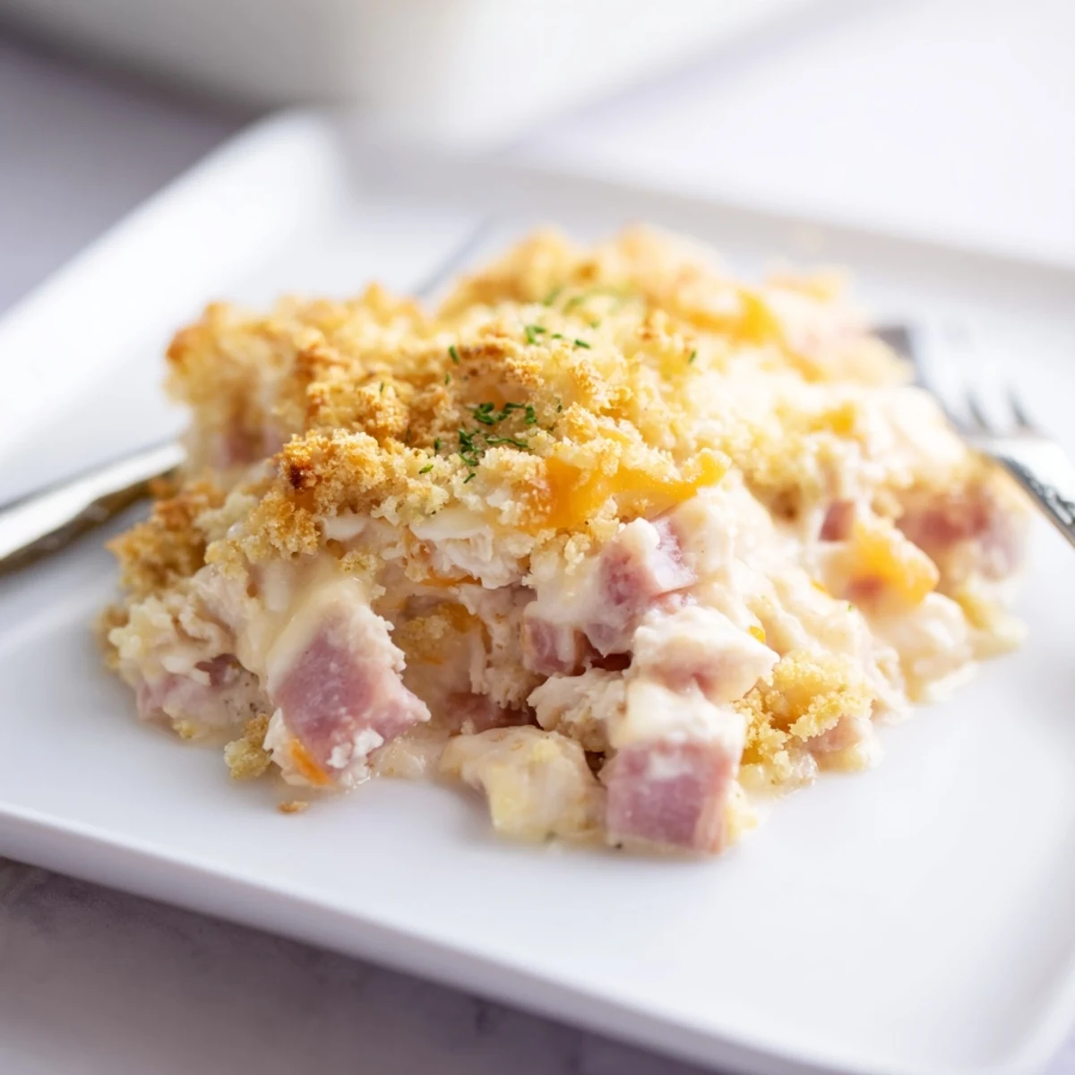 Steam rises from a golden-topped Chicken Cordon Bleu Casserole ready to be served for dinner.