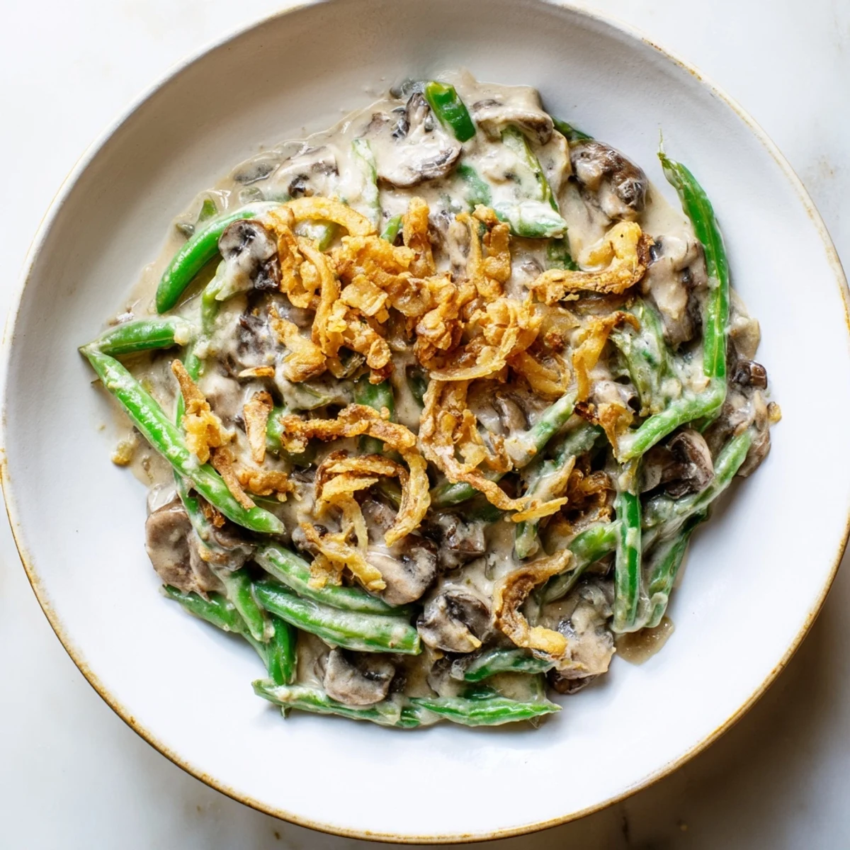 Green Bean Casserole with Crispy Onions baked golden brown and bubbling, served in a ceramic dish on a rustic table.