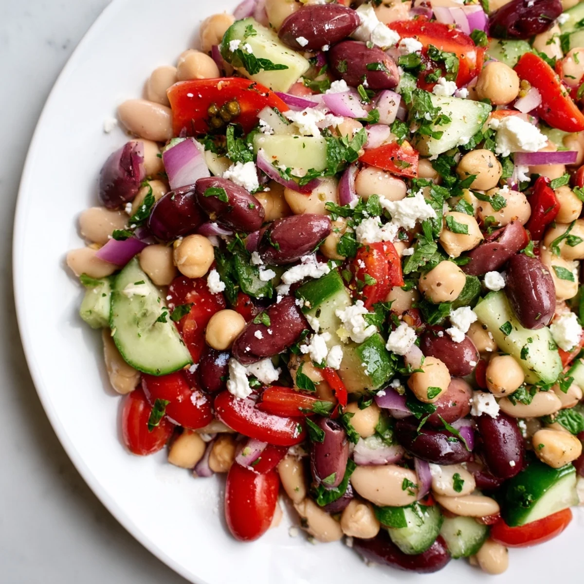 Overhead view of Mediterranean Dense Bean Salad with vibrant beans and vegetables glistening in olive oil dressing, perfect as a gluten-free vegetarian side dish.