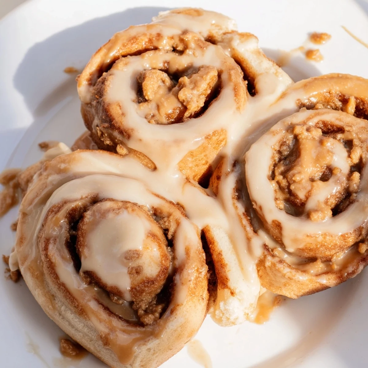A tray of freshly baked Soft and Gooey Biscoff Cinnamon Rolls served for breakfast, with a cup of coffee beside them.