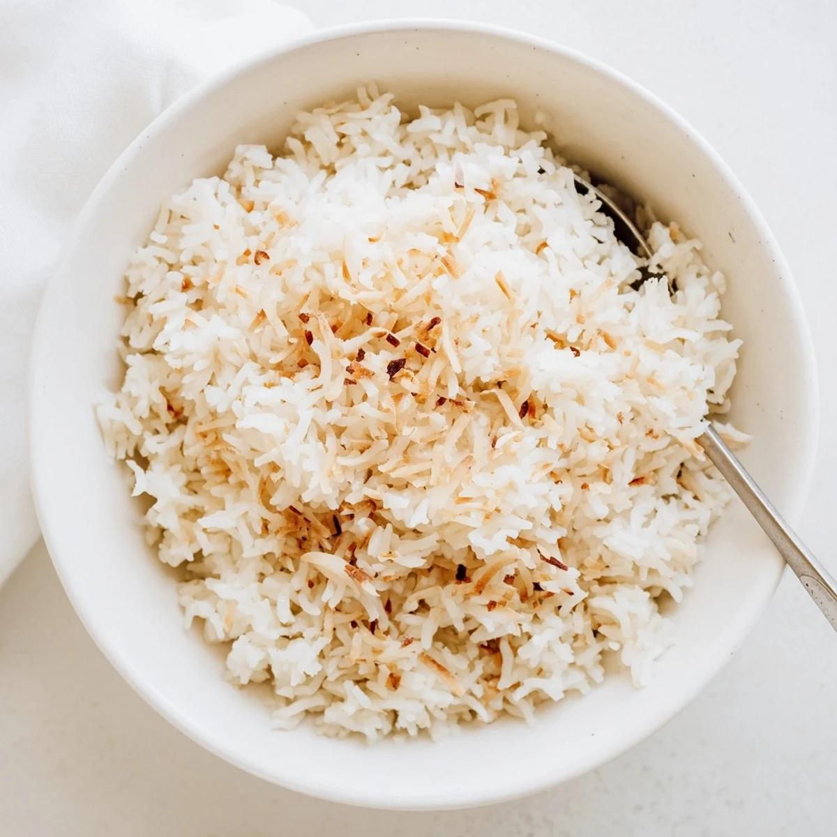 Fluffy grains of The Best Coconut Rice steam gently, infused with coconut milk and a hint of salt for a fragrant side dish.