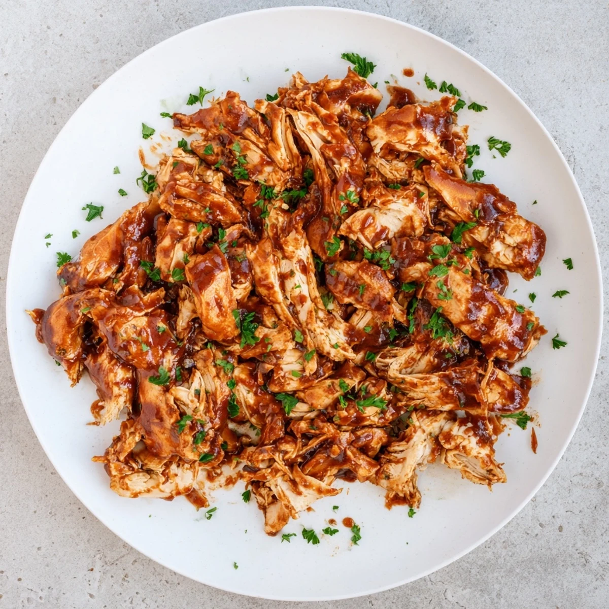 Tender Sweet Baby Rays Crockpot Chicken cooked in the slow cooker with tangy barbecue glaze, served on a fluffy bun.