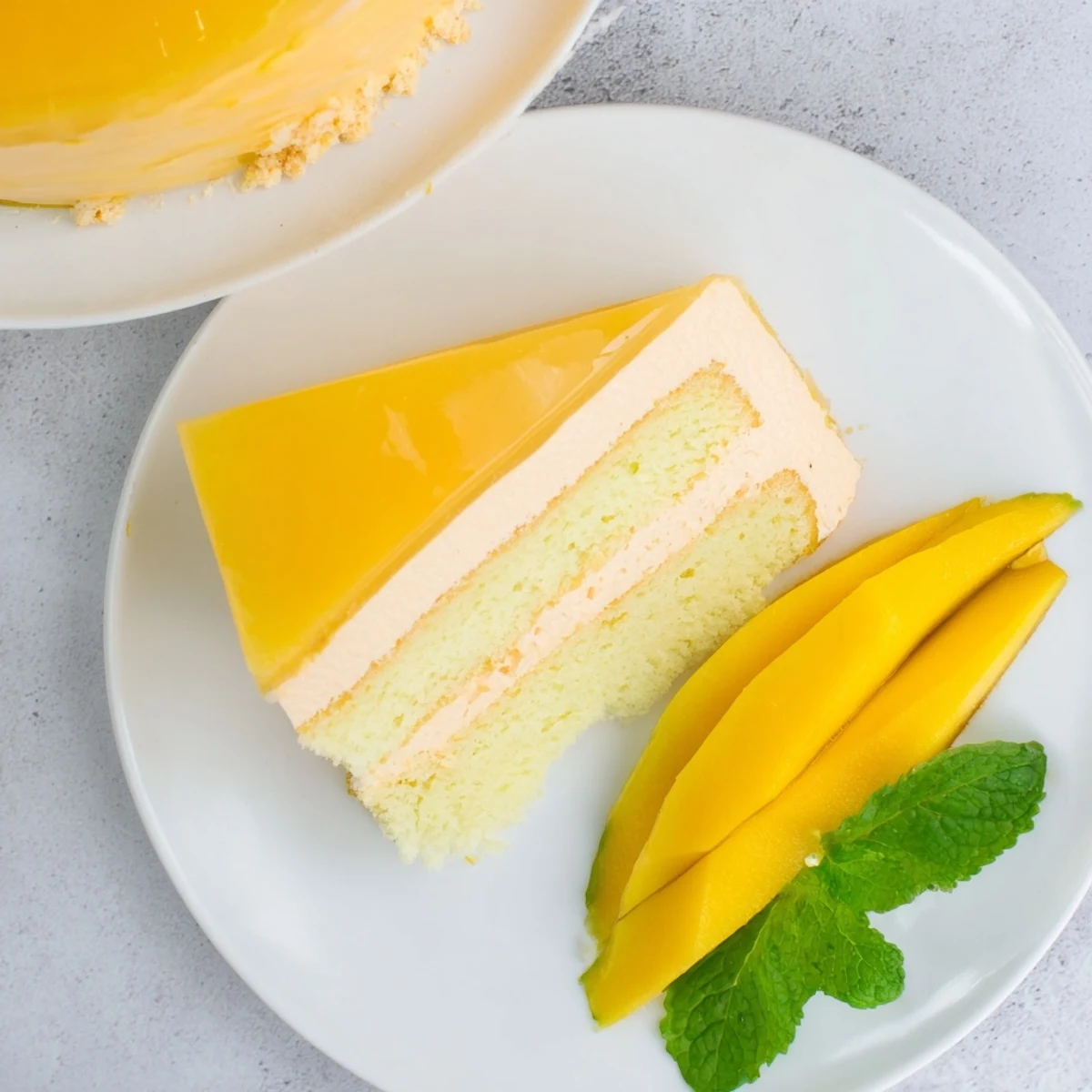 Slice of mango mousse cake showing smooth creamy texture and vibrant glaze