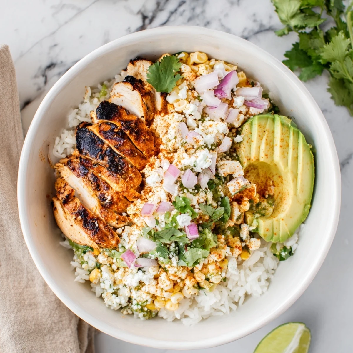 Street corn chicken rice bowl featuring grilled spiced chicken, creamy corn, and fresh avocado slices