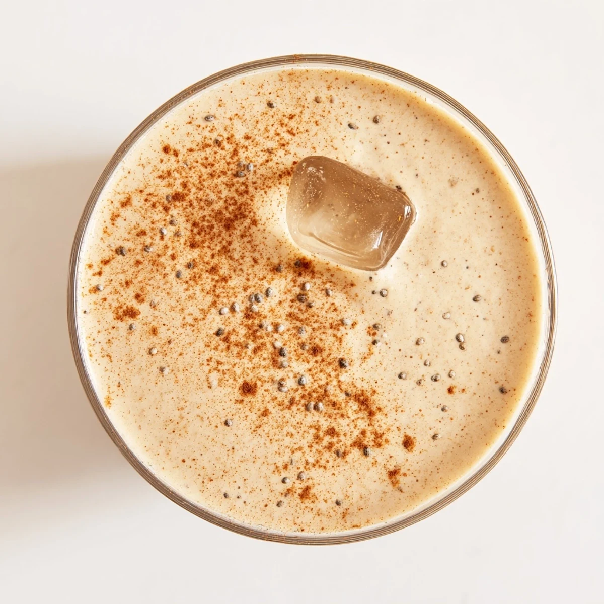 Thick creamy Greek yogurt banana smoothie poured into a glass topped with fresh banana slices