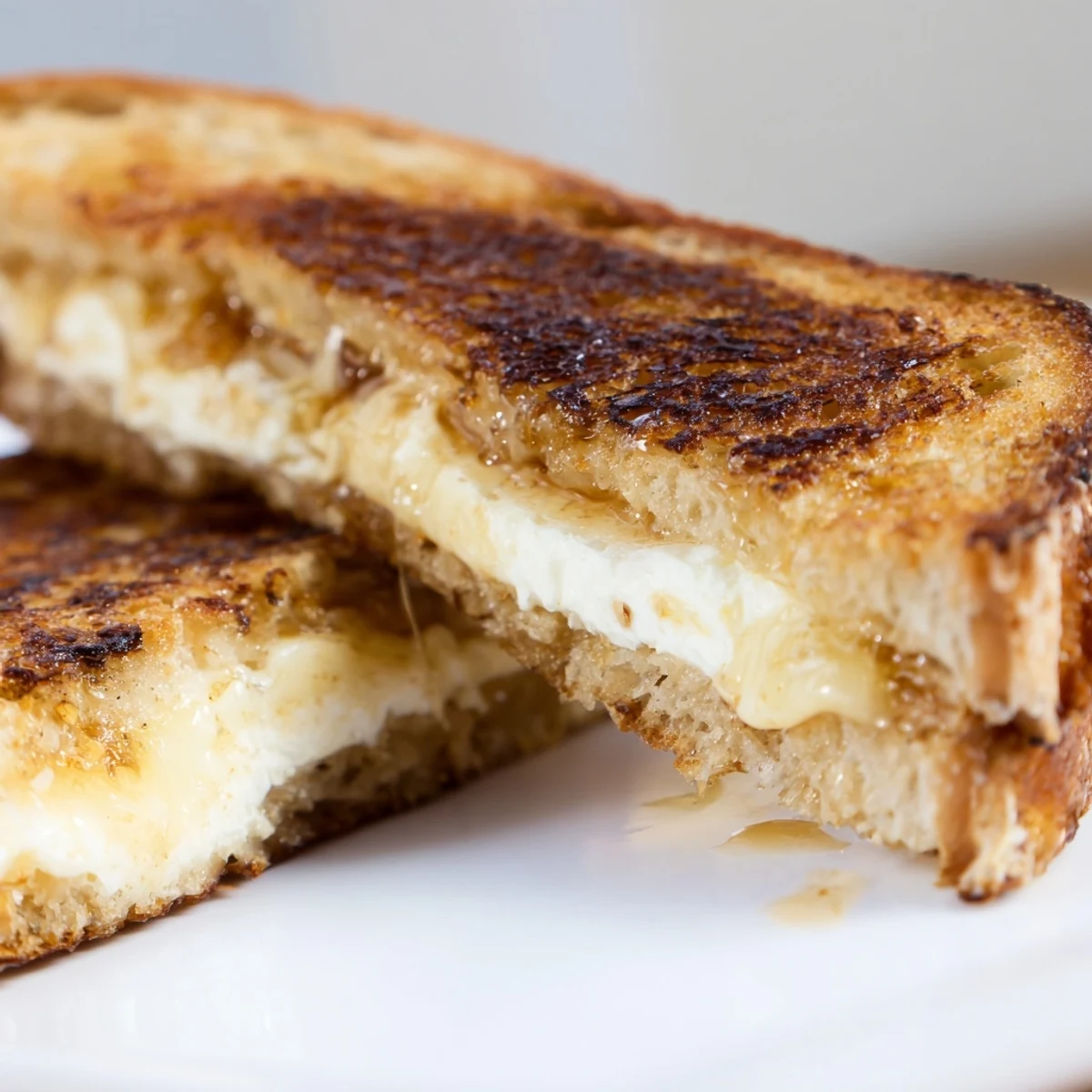 Cut sandwich revealing creamy goat cheese and sweet honey layers inside perfectly toasted rustic country bread