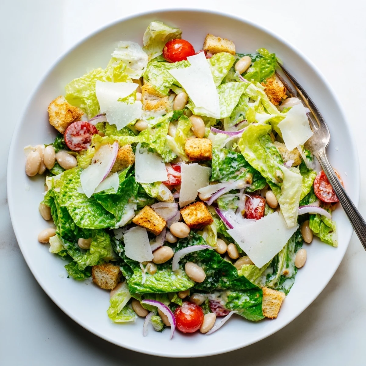 Fresh butter bean Caesar salad with crisp romaine, shaved Parmesan, and golden croutons drizzled with creamy dressing