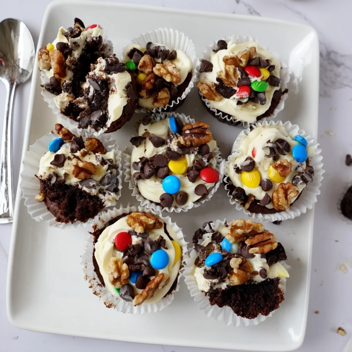 Rich fudgy loaded brownie cheesecake cups topped with colorful candy and chocolate chunks