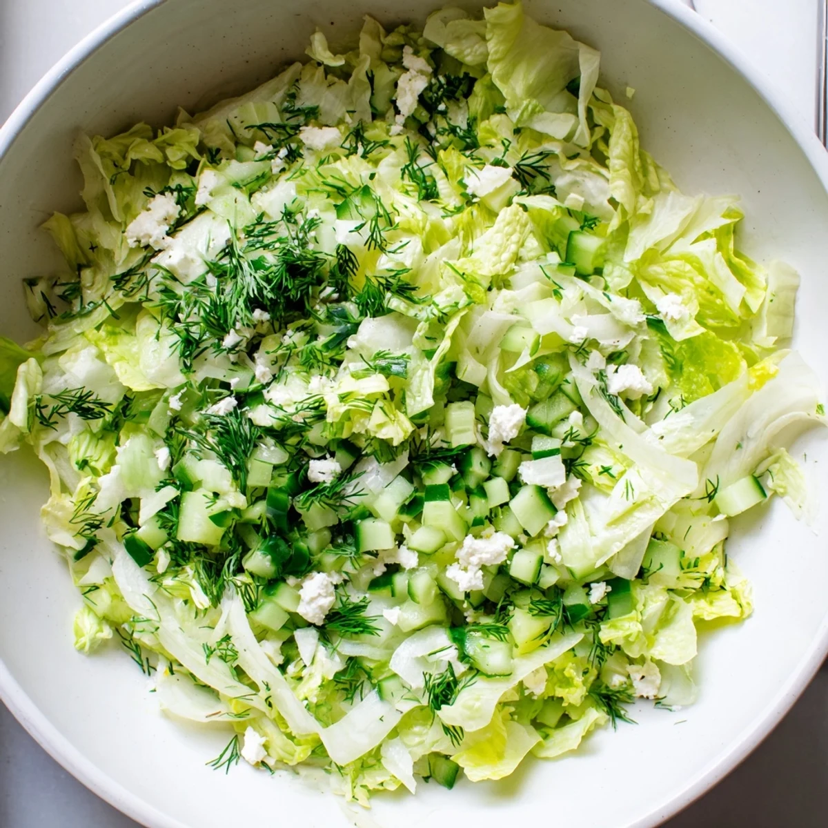 Fresh Maroulosalata Greek salad with crisp romaine, fragrant herbs, and bright lemon dressing in a white bowl