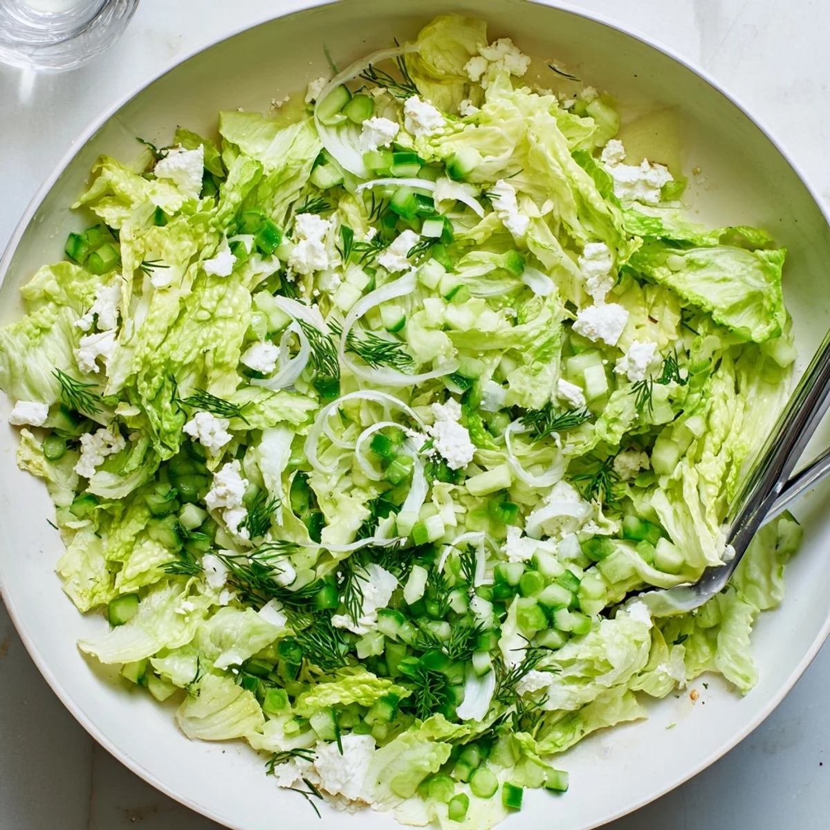 Classic Maroulosalata recipe featuring shredded romaine lettuce tossed with fresh dill, mint, and olive oil vinaigrette