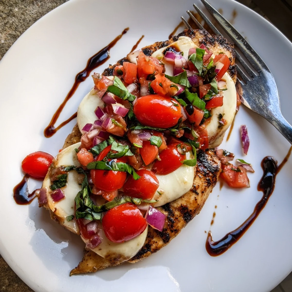 Savory mozzarella bruschetta chicken with juicy diced tomatoes, fresh basil, and bubbly baked cheese