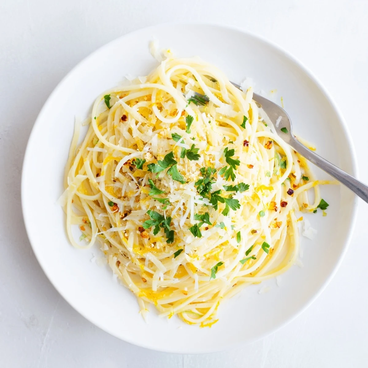 Twirled garlic butter pasta served on a rustic wooden board with melted butter coating each spaghetti strand.