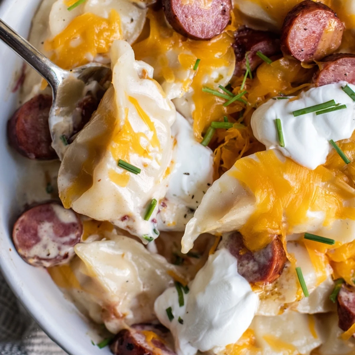 Golden Crock Pot Pierogi Casserole with melted cheddar over tender pasta and smoky kielbasa slices
