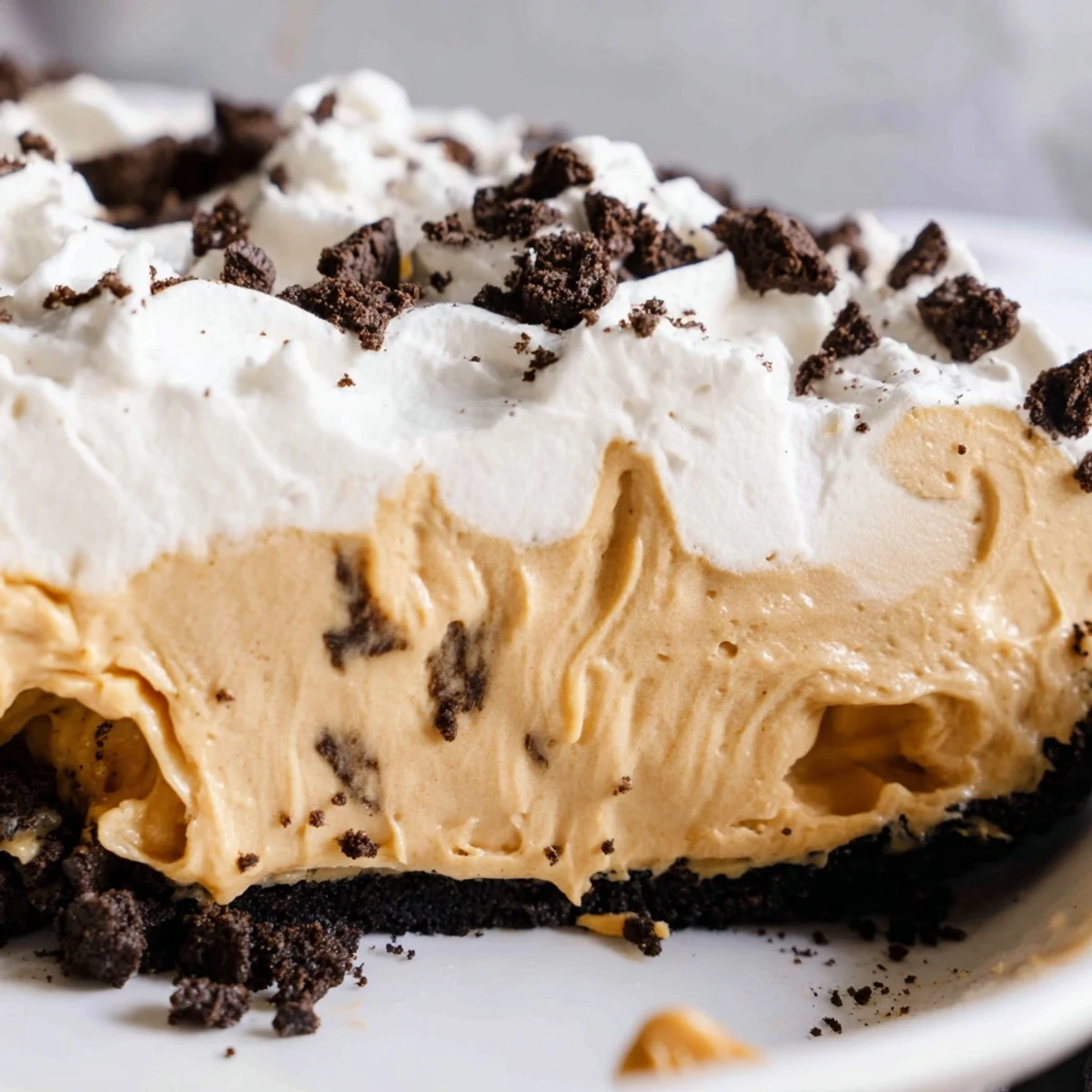 Rich peanut butter Oreo pie in a dark chocolate crust garnished with crushed cookies