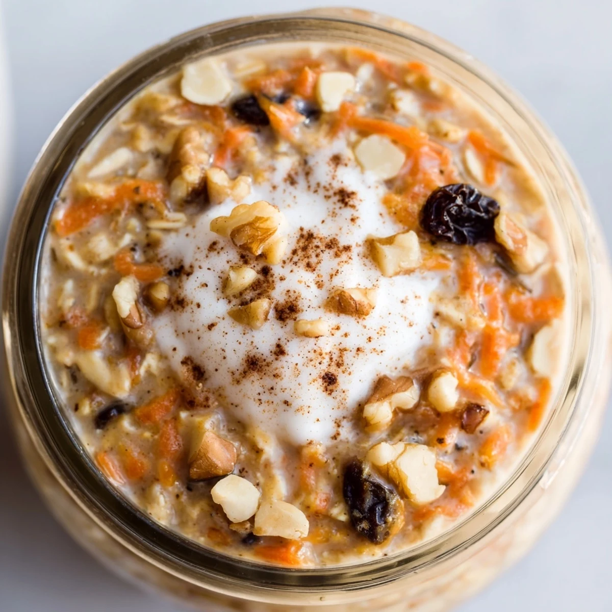 Carrot cake overnight oats with grated carrots, raisins, and a generous dollop of Greek yogurt