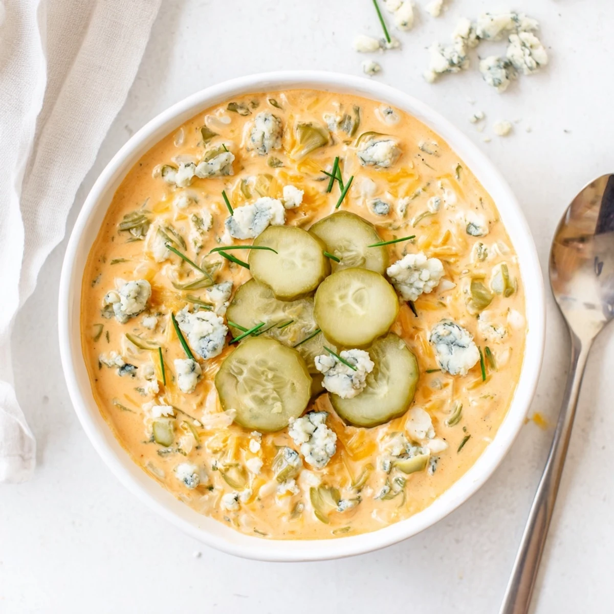 Creamy buffalo pickle dip in a rustic bowl with tortilla chips ready for dipping