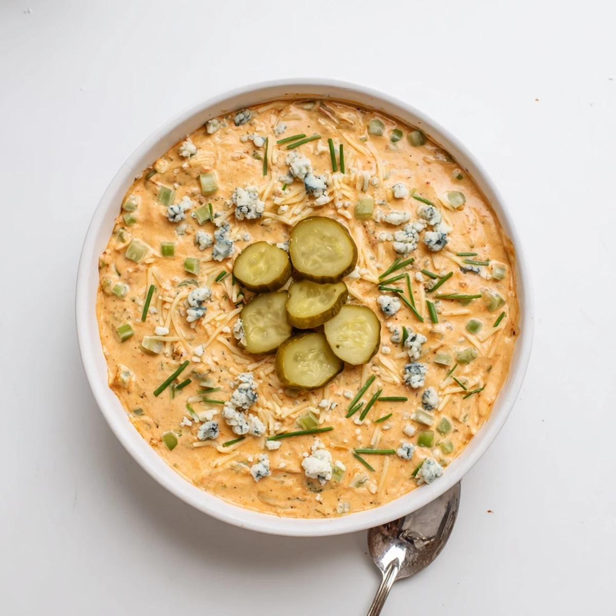 Zesty buffalo pickle dip topped with fresh chives and pickle slices for garnish
