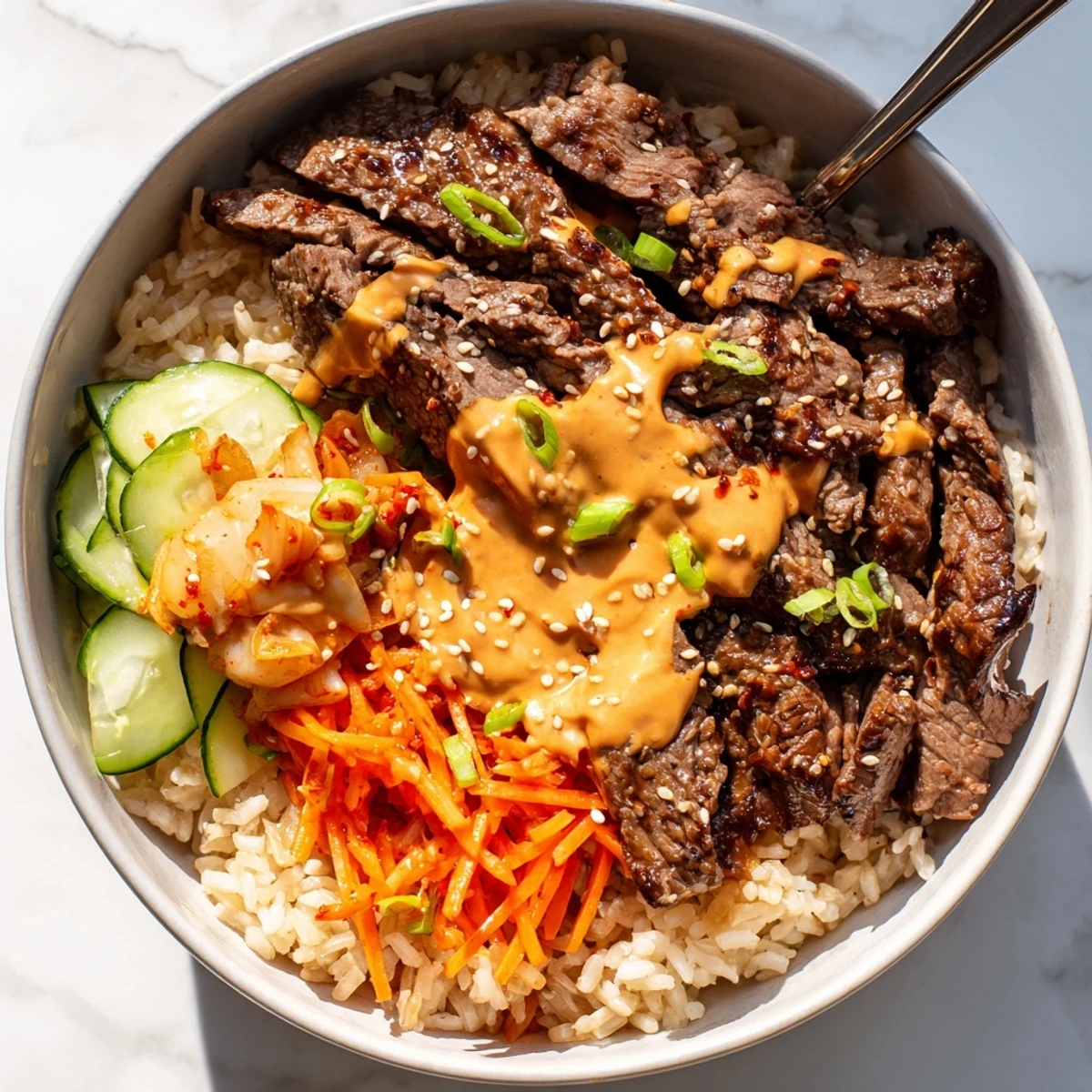 Sliced Korean BBQ steak over fluffy jasmine rice drizzled with spicy cream sauce