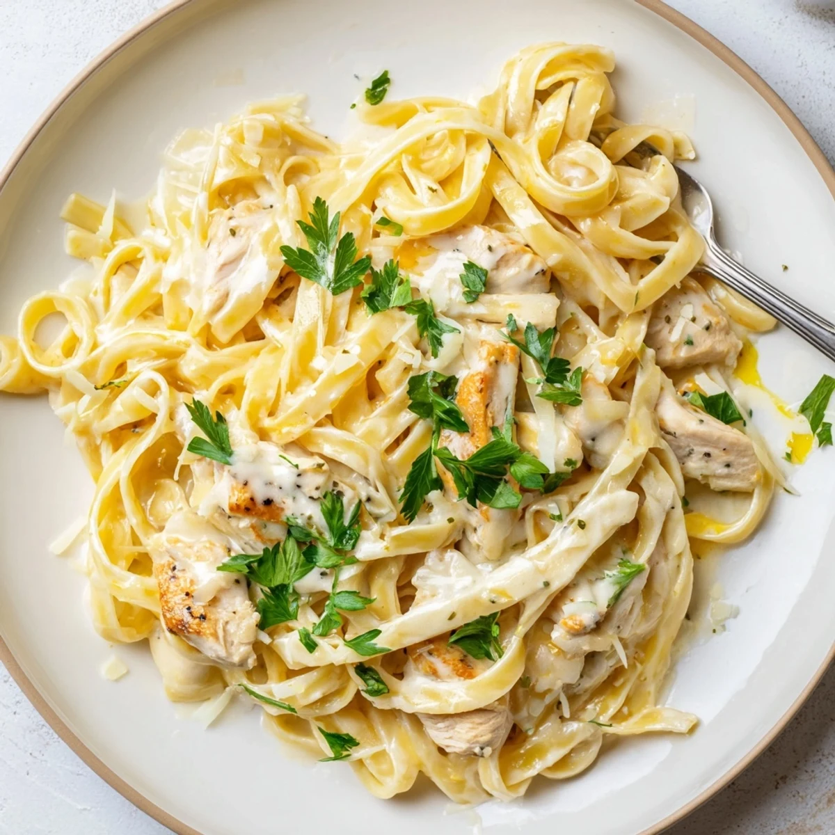 Creamy Garlic Chicken Pasta plated with parsley, steaming, rich garlic cream sauce