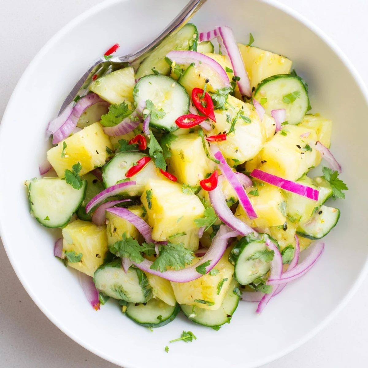 Chilled Pineapple Cucumber Salad tossed with cilantro and thinly sliced red onion