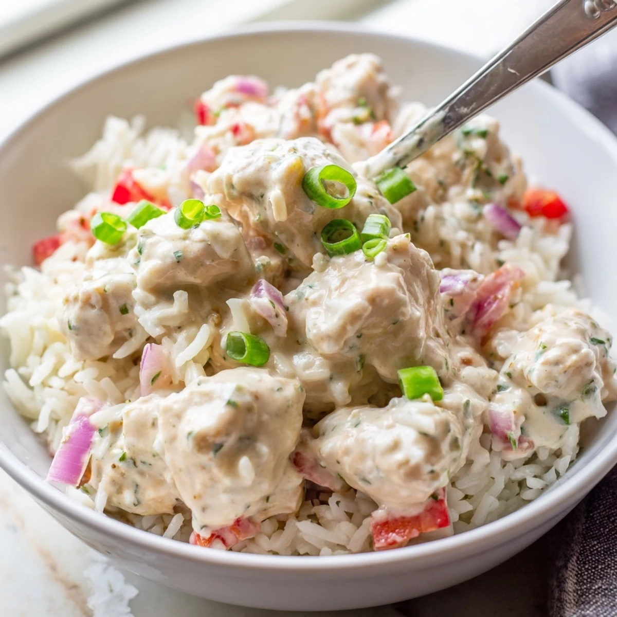 Golden chicken pieces swimming in rich Cajun cream sauce over fluffy white rice
