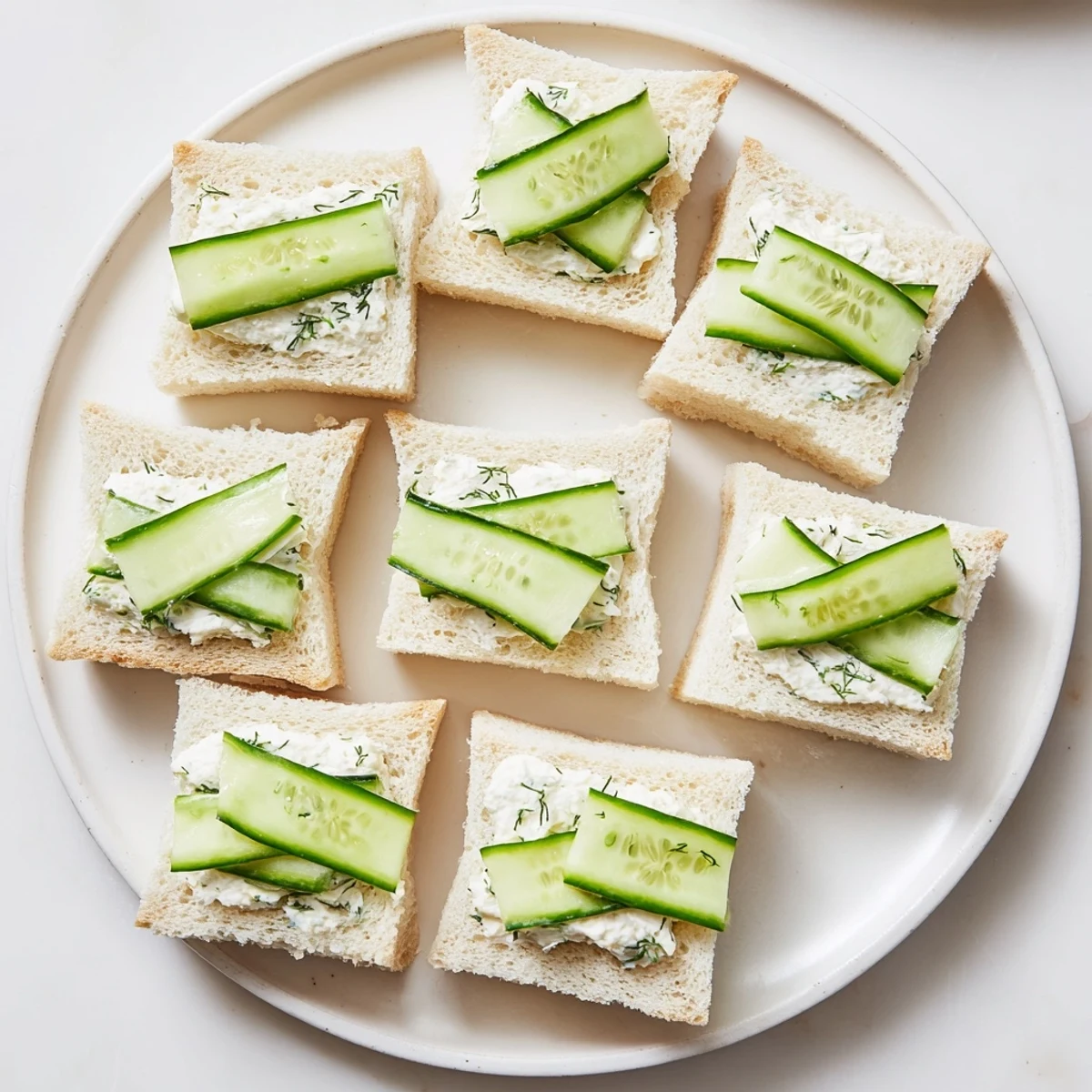 Fresh cucumber salad sandwiches featuring crisp cucumber slices on soft white bread with creamy herb spread