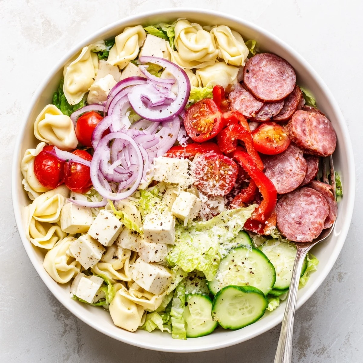 Hearty tortellini salad layered with roasted red peppers, pepperoncini, and crunchy cucumber in a creamy herb vinaigrette