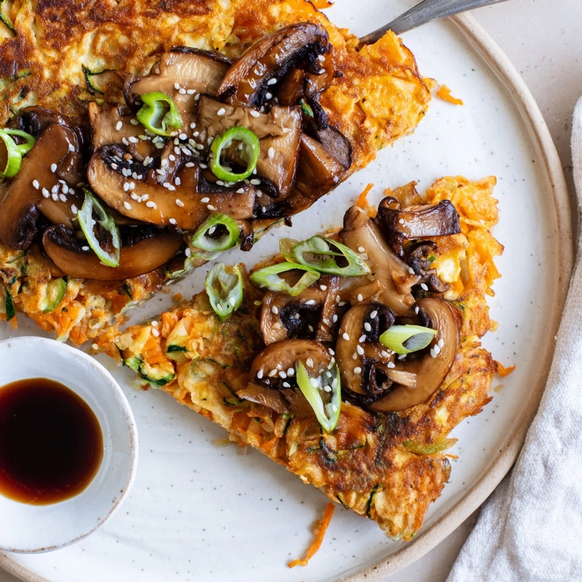 Pan-sliced Vegan Kimchi Pancake With Tamari Mushrooms served with spicy dipping sauce  
