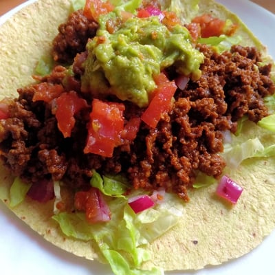 Freshly assembled beef tacos with creamy guacamole and zesty homemade salsa for a vibrant meal.